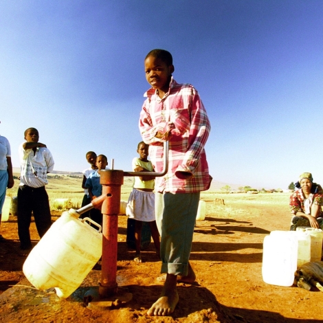 A boy pumps water