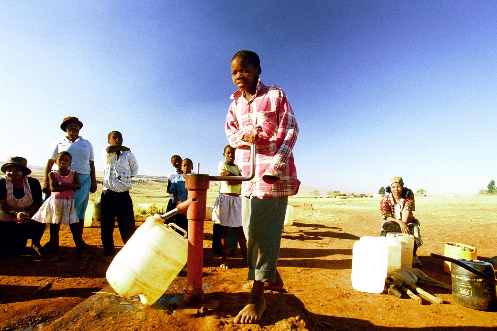 A boy pumps water